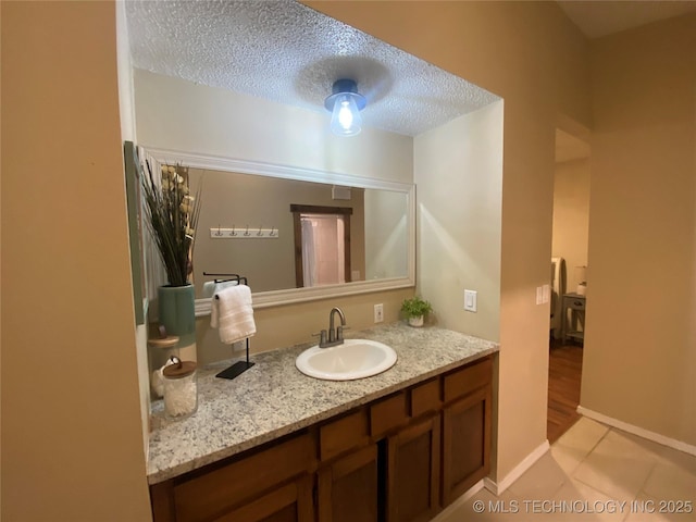 bathroom featuring vanity, tile patterned flooring, and a textured ceiling