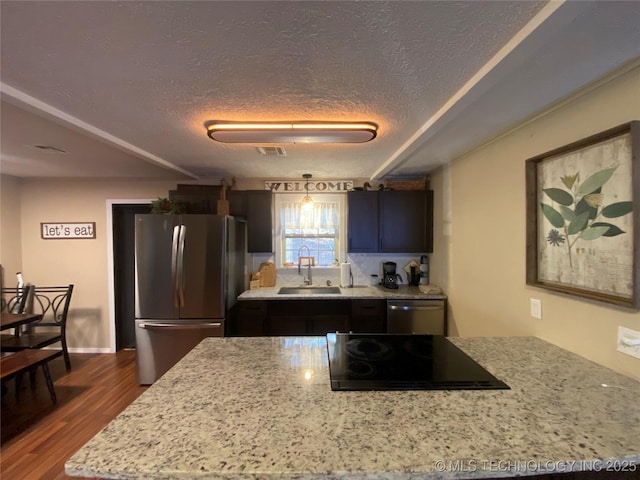 kitchen featuring sink, hardwood / wood-style flooring, stainless steel appliances, and a textured ceiling