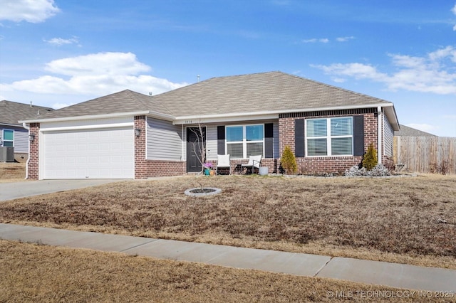 ranch-style house featuring a garage, central AC, and a front lawn