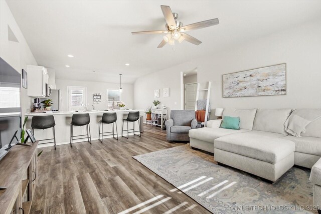 living room with light hardwood / wood-style flooring and ceiling fan