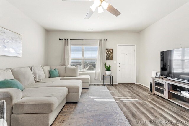 living room with wood-type flooring and ceiling fan