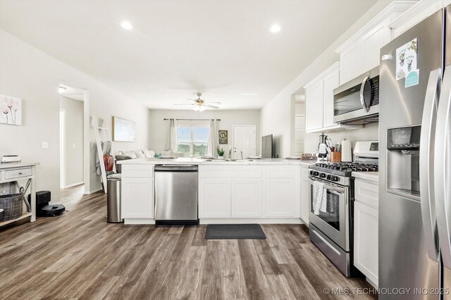 kitchen with sink, stainless steel appliances, light hardwood / wood-style floors, and white cabinets