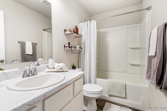 full bathroom featuring hardwood / wood-style flooring, vanity, shower / bathtub combination with curtain, and toilet