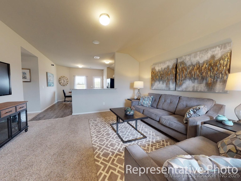 carpeted living room with lofted ceiling