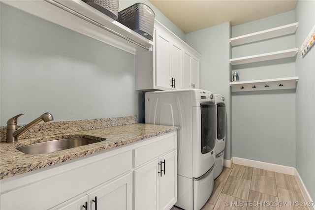 clothes washing area with cabinets, sink, and washing machine and dryer