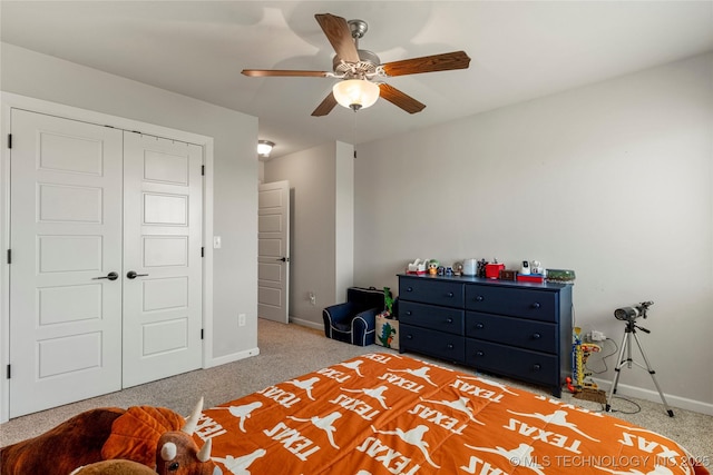 carpeted bedroom featuring ceiling fan and a closet