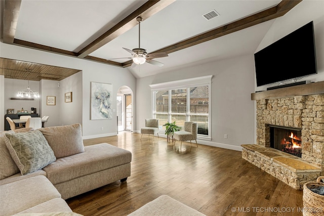 living room with ceiling fan, wood-type flooring, a fireplace, and vaulted ceiling with beams