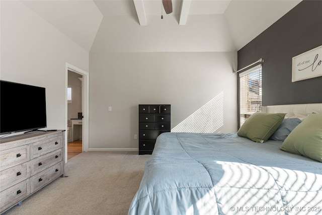 bedroom featuring ensuite bath, light colored carpet, and vaulted ceiling with beams