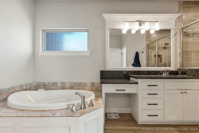 bathroom featuring hardwood / wood-style flooring, vanity, and shower with separate bathtub