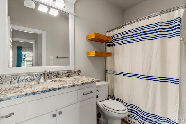 bathroom with vanity, a shower with shower curtain, and toilet