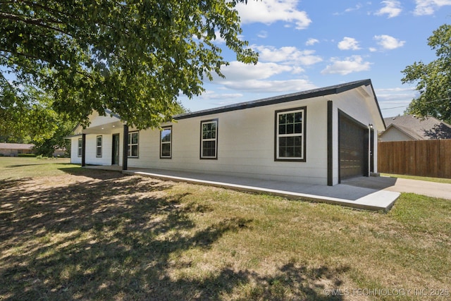 back of property with a yard and a patio area