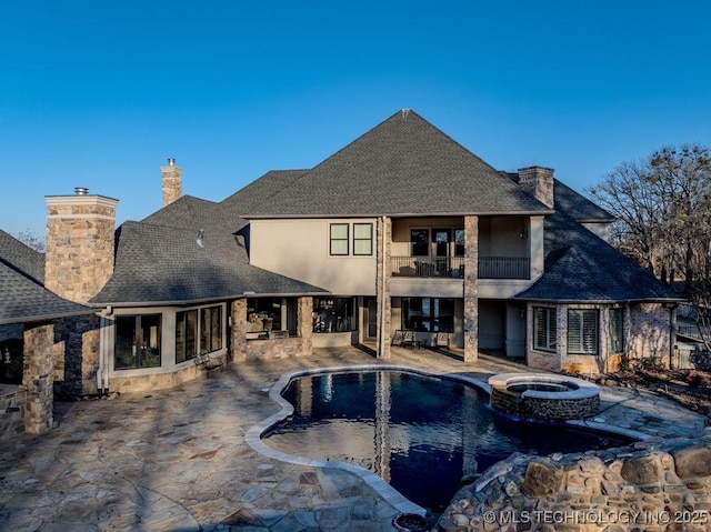 view of pool featuring a patio and an in ground hot tub