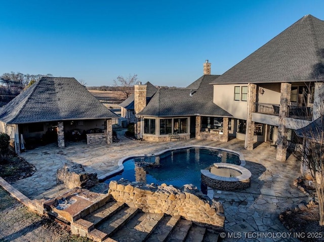 view of swimming pool with a bar, a patio, and an in ground hot tub