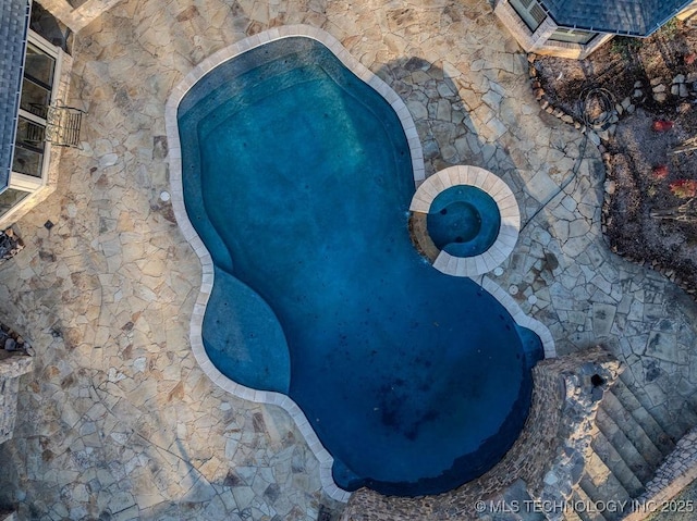 view of swimming pool with an in ground hot tub