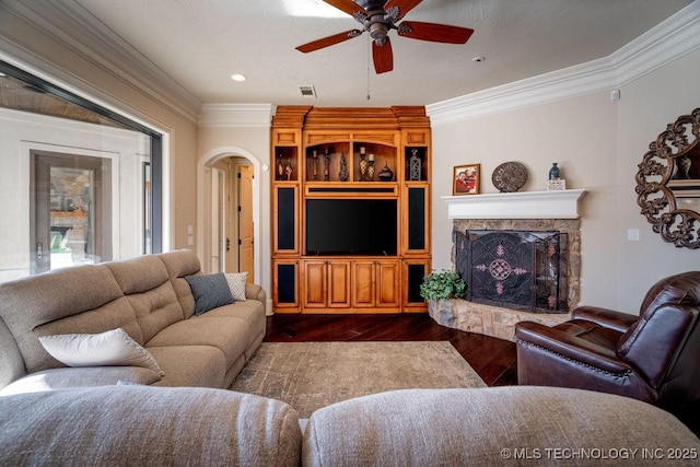 living room with dark wood-type flooring, ceiling fan, and ornamental molding