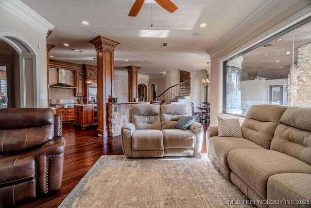 living room with dark hardwood / wood-style flooring, ornamental molding, ceiling fan, and ornate columns