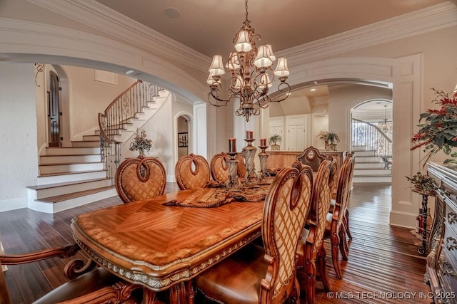 dining space with dark hardwood / wood-style flooring, ornamental molding, and a chandelier