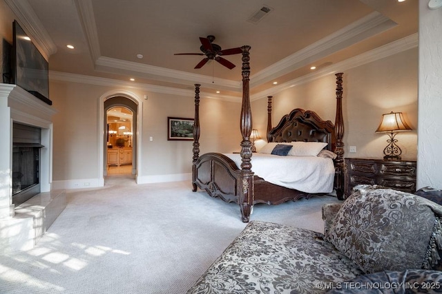 bedroom featuring crown molding, ceiling fan, a raised ceiling, and light carpet