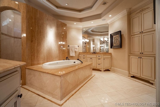 bathroom featuring a chandelier, ornamental molding, vanity, a tray ceiling, and tiled bath