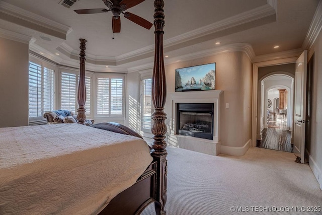 bedroom featuring crown molding, carpet floors, a raised ceiling, and ceiling fan