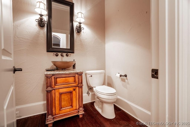 bathroom featuring vanity, hardwood / wood-style floors, and toilet