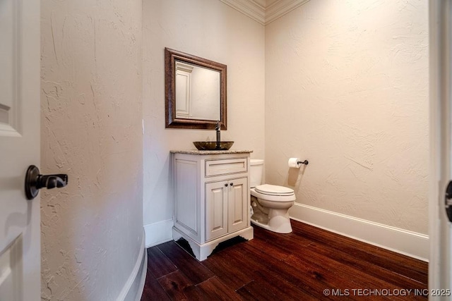 bathroom with hardwood / wood-style flooring, ornamental molding, toilet, and vanity