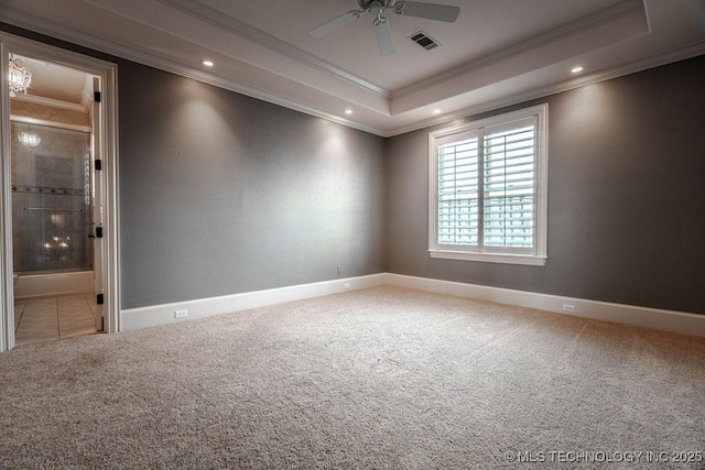 empty room with carpet floors, ornamental molding, a raised ceiling, and ceiling fan