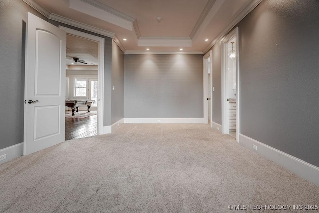 spare room featuring crown molding, a tray ceiling, and carpet floors