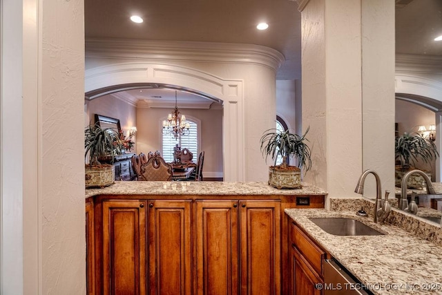 bar with an inviting chandelier, sink, crown molding, and light stone countertops