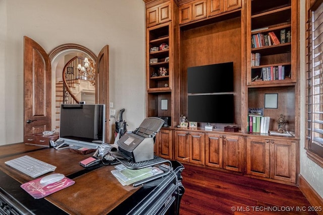 office space with dark hardwood / wood-style floors, built in features, and an inviting chandelier