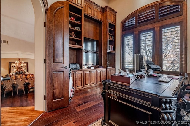 office space with a high ceiling, dark wood-type flooring, and a chandelier