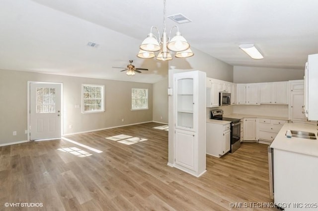 kitchen featuring lofted ceiling, white cabinetry, light hardwood / wood-style flooring, appliances with stainless steel finishes, and pendant lighting