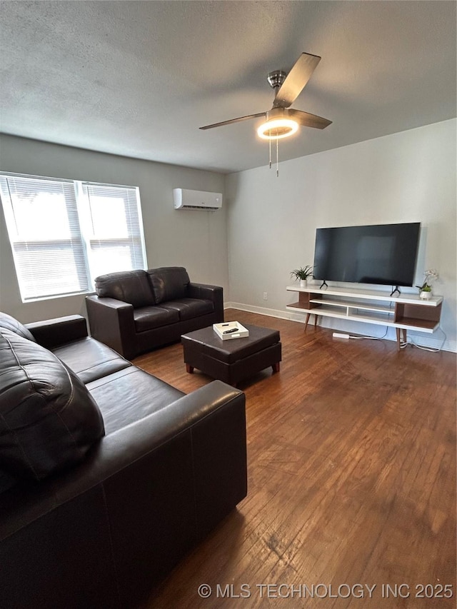 living room with ceiling fan, hardwood / wood-style flooring, a textured ceiling, and a wall mounted AC