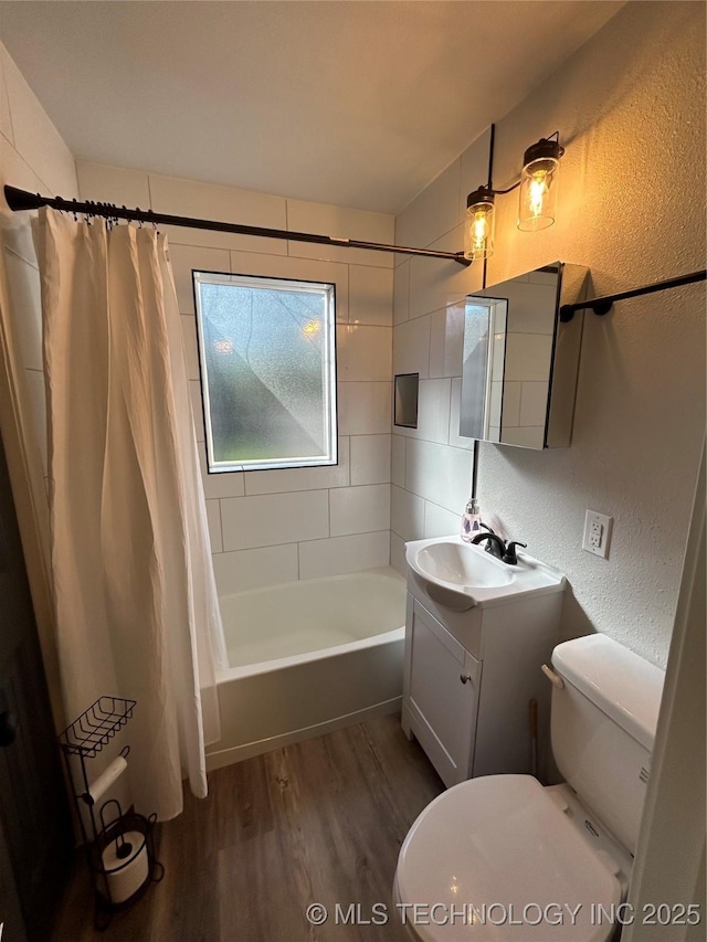 full bathroom featuring wood-type flooring, toilet, shower / bathtub combination with curtain, and vanity