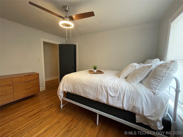 bedroom featuring wood-type flooring, crown molding, and ceiling fan