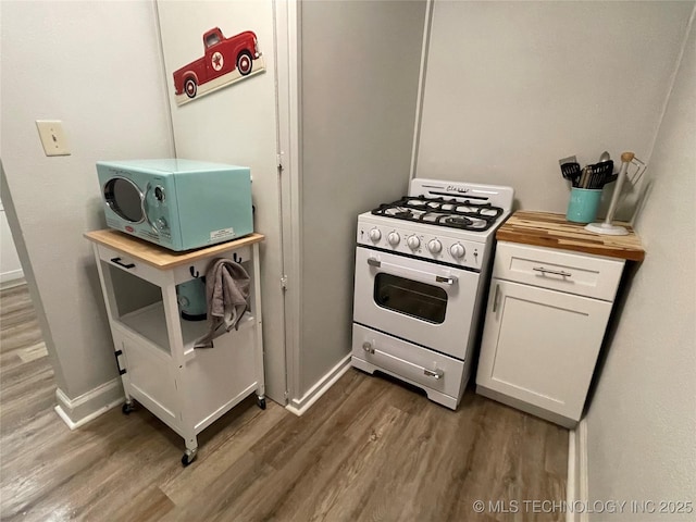 kitchen featuring white cabinetry, dark wood-type flooring, wood counters, and gas range gas stove