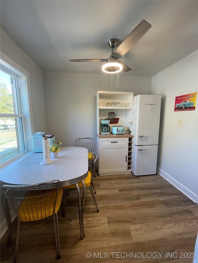 dining area with hardwood / wood-style floors and ceiling fan