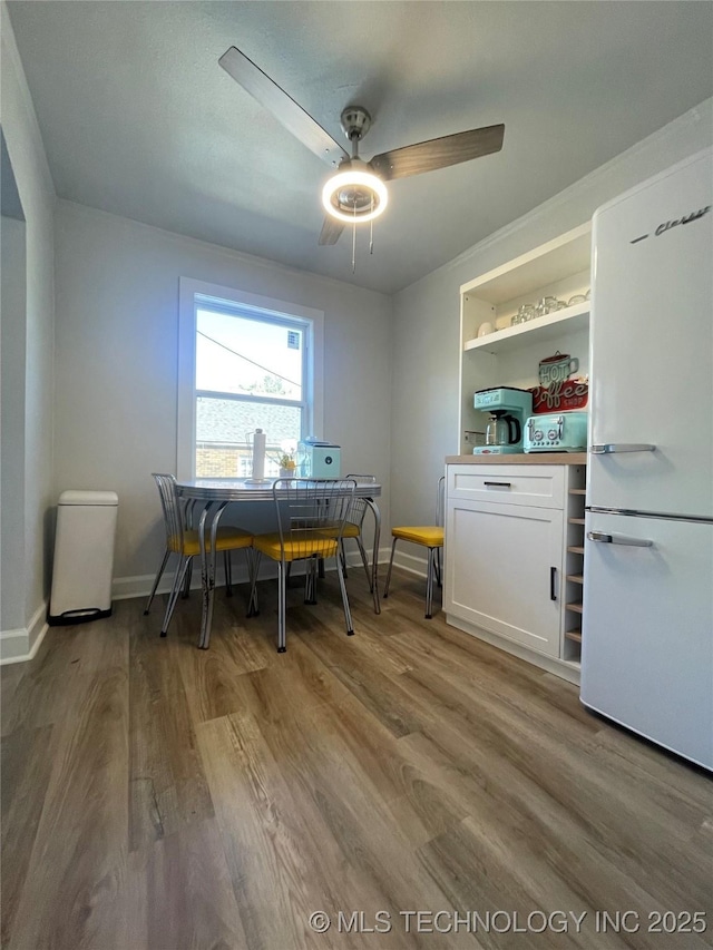 dining room with hardwood / wood-style floors, ceiling fan, and built in shelves