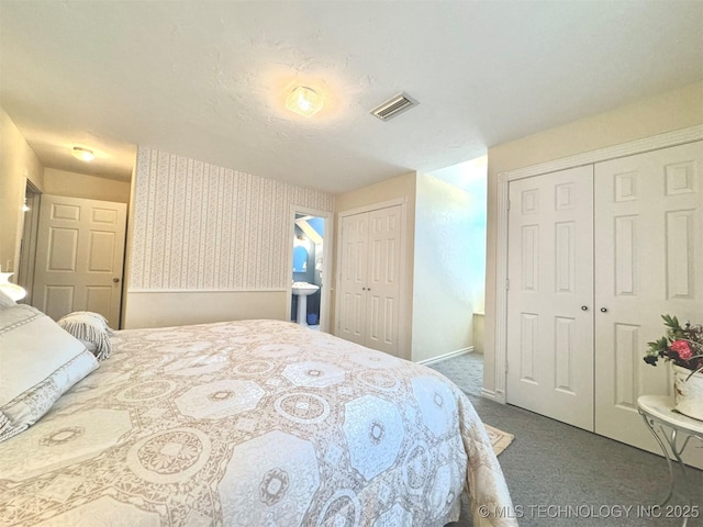 bedroom featuring ensuite bath and carpet