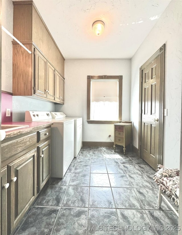 clothes washing area featuring independent washer and dryer and cabinets