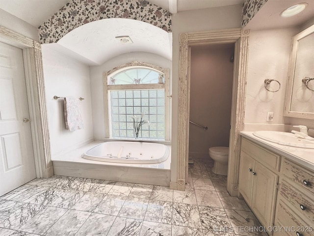 bathroom with vanity, toilet, and a bath