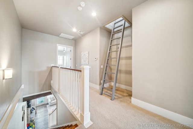 hall featuring a skylight and light carpet