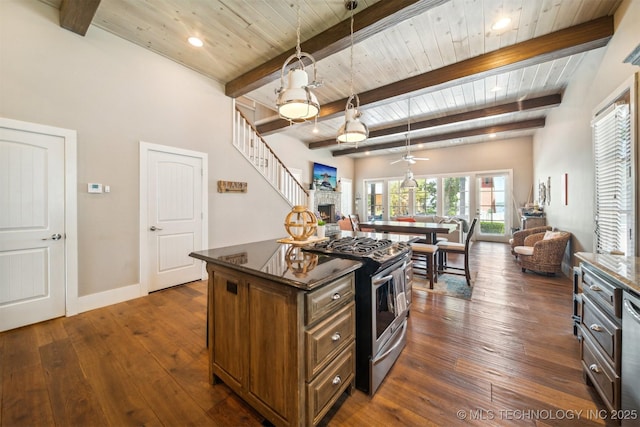 kitchen with a center island, a fireplace, stainless steel range with gas cooktop, wooden ceiling, and beamed ceiling