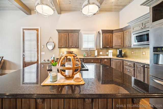 kitchen with sink, beamed ceiling, stainless steel appliances, and wooden ceiling