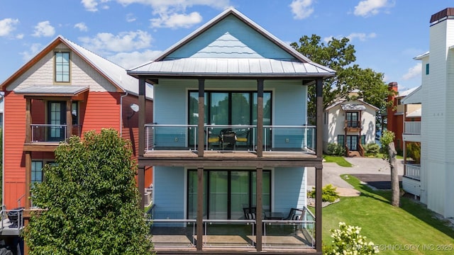 back of property with a balcony and a yard