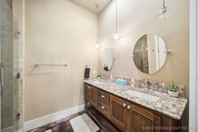 bathroom featuring a shower with door and vanity