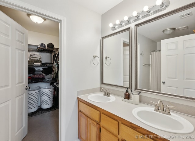 bathroom featuring walk in shower and vanity