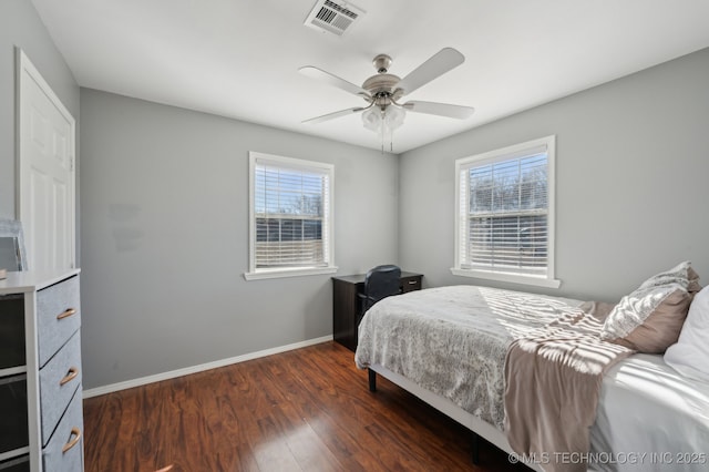 bedroom featuring multiple windows, dark hardwood / wood-style flooring, and ceiling fan