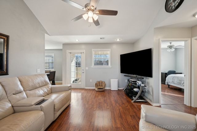 living room with lofted ceiling, dark wood-type flooring, and ceiling fan