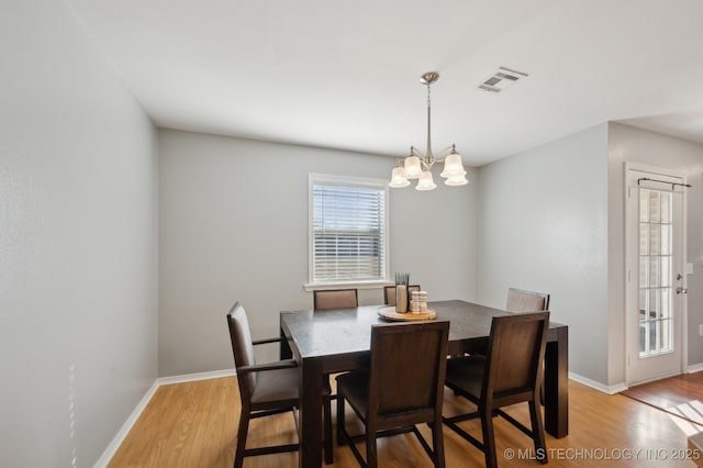 dining area featuring light hardwood / wood-style flooring and a chandelier